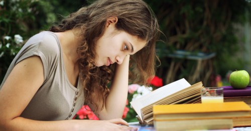 Mujer joven leyendo y estudiando al aire libre